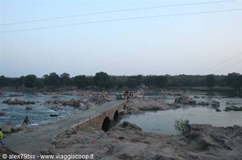 Old stone bridge crossing the boulder-strewn river at Hampi