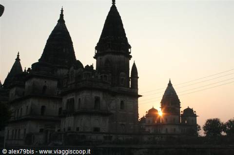 Orchha's stone cenotaphs, dark silhouettes against the morning sky