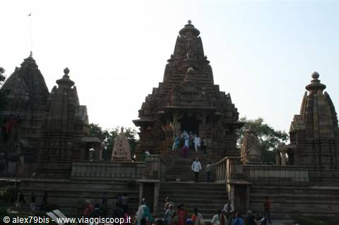 Tourists climb the stone temple staircase at Khajuraho in evening light