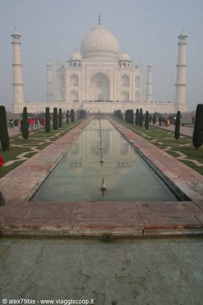 The Taj Mahal in the mist reflects in the long garden water channel