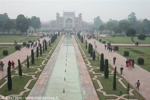 Long reflecting pool and cypress-lined walkway leading to the Taj Mahal gate
