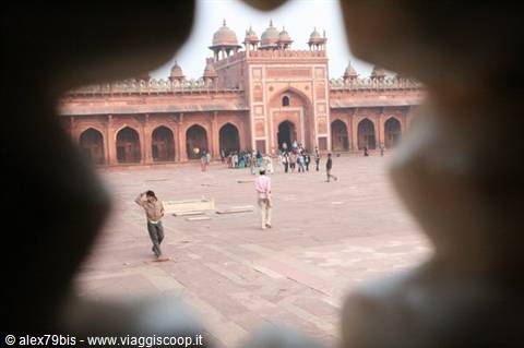Red sandstone courtyard of Jama Masjid in Fatehpur Sikri, visitors walking