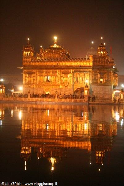 The Golden Temple of Amritsar illuminated at night, reflected in the sacred water