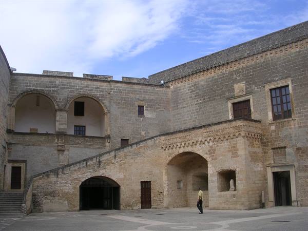 Inner courtyard of Copertino Castle, stone staircase and arched loggia