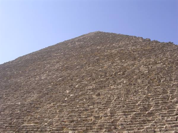 Great Pyramid of Giza, sunlit stone blocks rising against clear blue sky