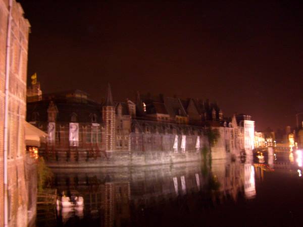 Ghent: medieval facades along the canal at night, golden lights reflected in water
