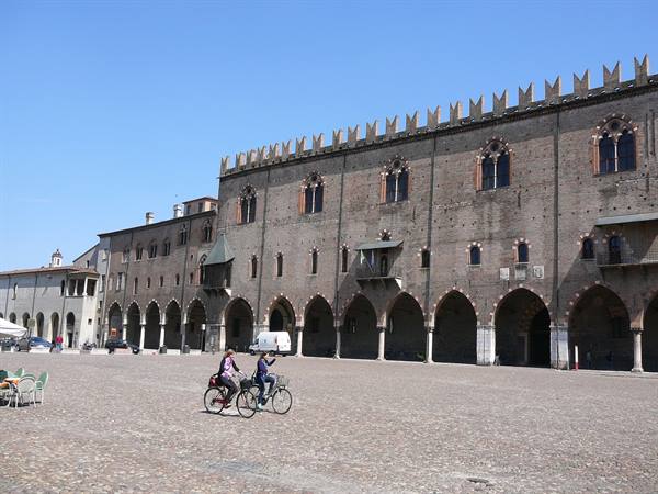 Cyclists on the cobbled square in front of Palazzo Ducale, Mantua