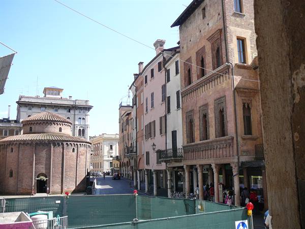 The Rotonda di San Lorenzo beside medieval brick houses under sunny sky