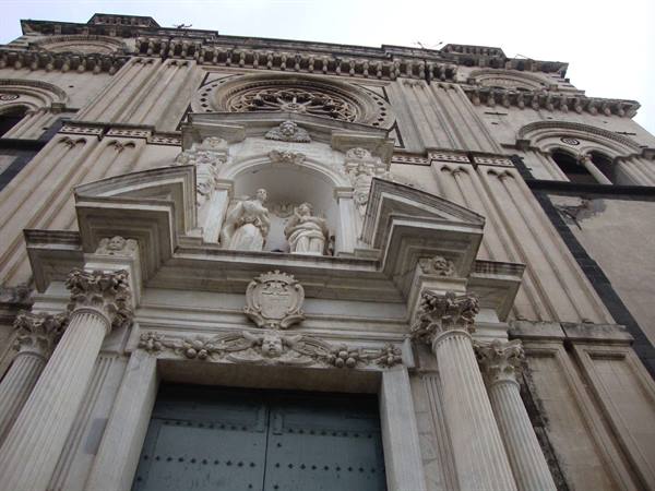 Baroque facade of Catania Cathedral with marble statues and rose window