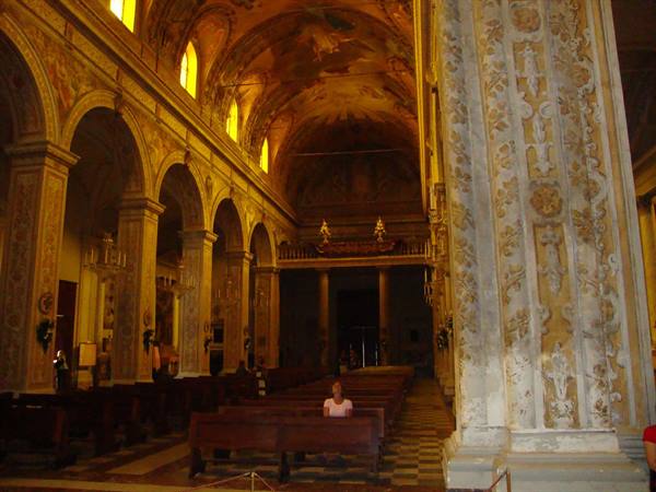 Baroque church interior: frescoed vaults, ornate stucco columns, wooden pews