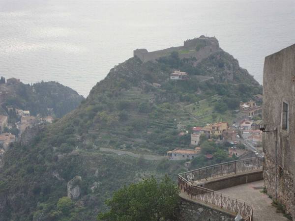 Monte Tauro with Taormina castle above the houses, hazy light