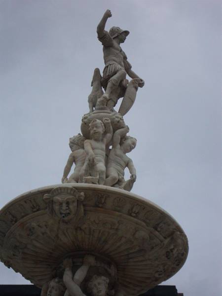 Orion Fountain in Messina, marble statues of cherubs under a gray sky