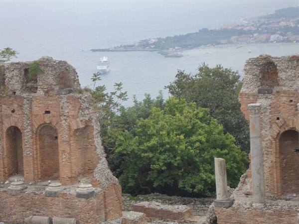 brick ruins of Taormina's Greek theatre overlooking the misty bay