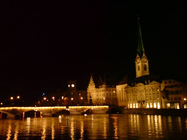 Night in Zurich: the Limmat river reflecting lights and Fraumünster spire