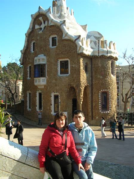 Couple sitting on mosaic bench in front of Gaudí's house at Park Güell