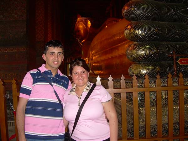 Couple posing beside the golden Reclining Buddha at Wat Pho