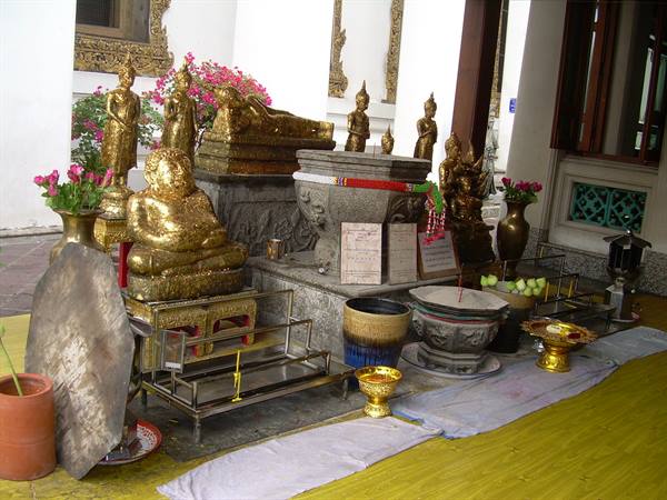 Golden Buddha statues and stone incense burner at Wat Pho temple