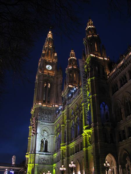 Vienna City Hall at night, Gothic towers lit green against blue sky