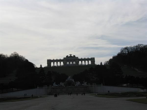 The Gloriette at Schönbrunn above the fountain, cloudy sky and visitors