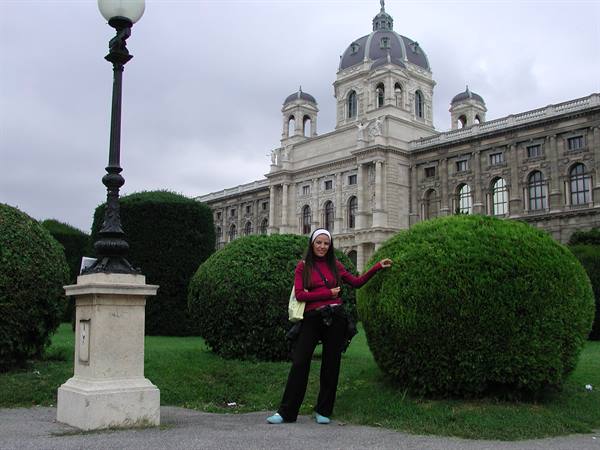 Woman beside rounded hedge in front of Vienna's Naturhistorisches Museum