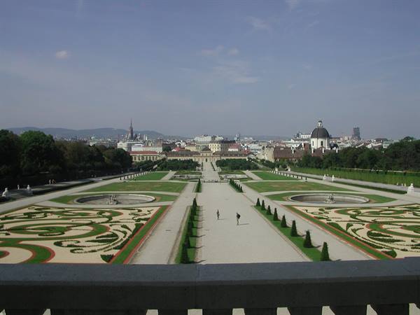 Belvedere gardens in Vienna, symmetrical paths between flowerbeds and hedges, tourists strolling