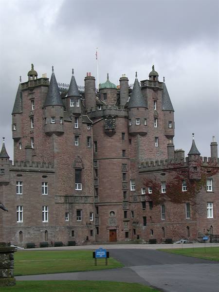 Glamis Castle, pink stone facade with conical turrets under grey sky