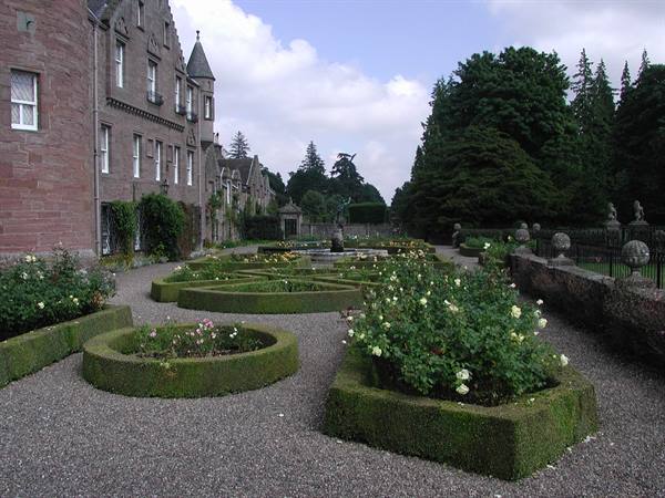 Formal garden with box hedges and roses beside a stone castle, Glamis