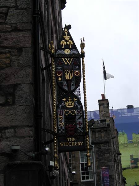 Ornate painted sign of The Witchery restaurant on stone facade in Edinburgh