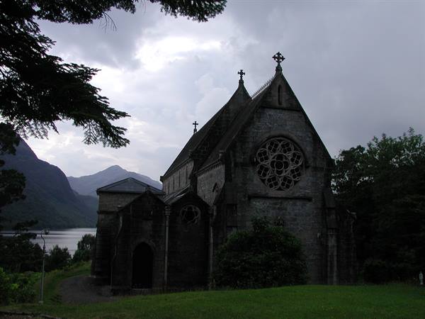 Gothic stone church with rose window, Kylemore, beneath cloudy sky