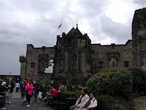 Tourists near the War Memorial at Edinburgh Castle under cloudy skies
