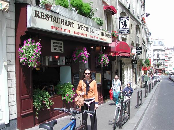 Tourist in orange next to bicycles outside the L'Étoile du Berger restaurant