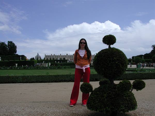 Woman beside a topiary sphere in the gardens of Versailles