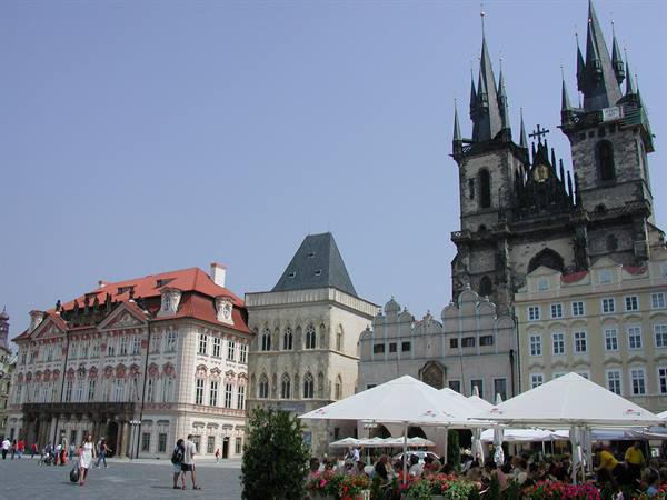 Tourists and white umbrellas beneath Týn Church in Prague