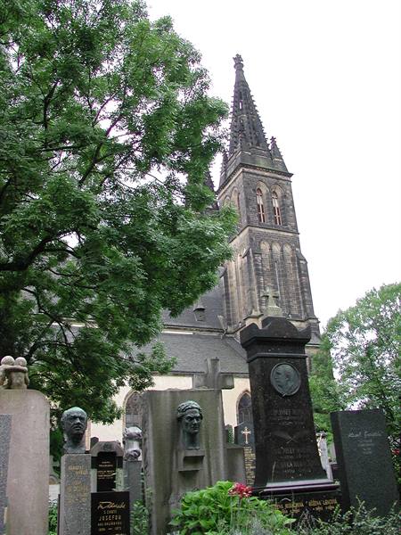 Vyšehrad cemetery: stone busts on graves before Prague's neo-Gothic basilica