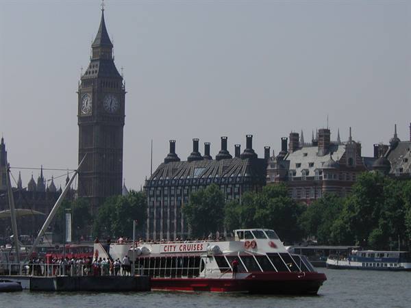 City Cruises boat on the Thames with Big Ben and Portcullis House behind