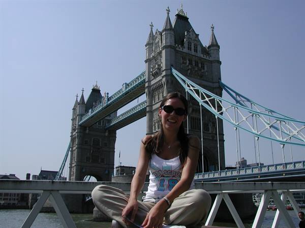 Girl sitting in front of Tower Bridge in London, blue sky