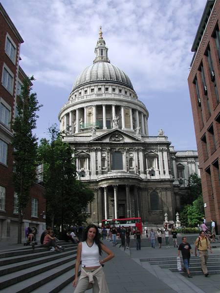Tourist posing on the steps in front of St Paul's Cathedral dome, London