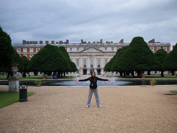 Girl with open arms in front of the fountain at Hampton Court Palace