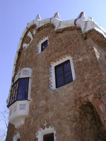 Stone house with undulating white mosaic roof by Gaudí at Parc Güell, Barcelona