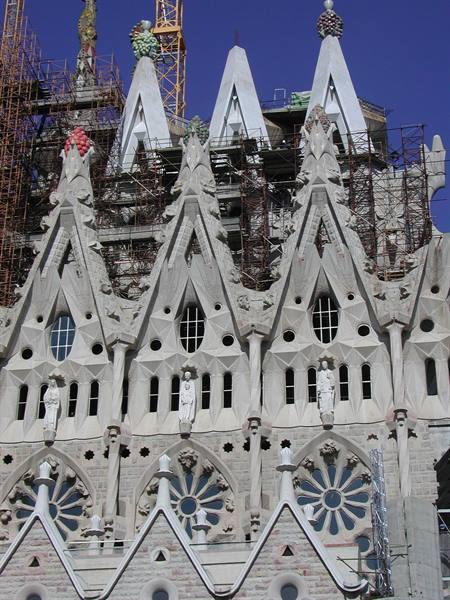 Sagrada Familia in Barcelona, stone spires with scaffolding under blue sky