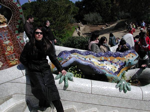 Woman beside Gaudí's mosaic salamander at Park Güell