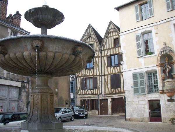Stone fountain with sculpted basins, half-timbered houses and niche statue, Place Plumereau