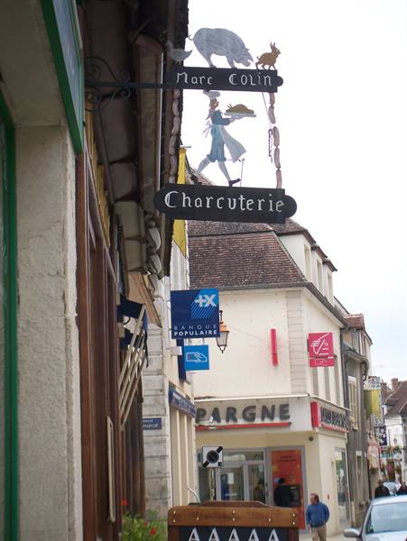 Wrought iron sign of Marc Colin butcher shop with pig and cook
