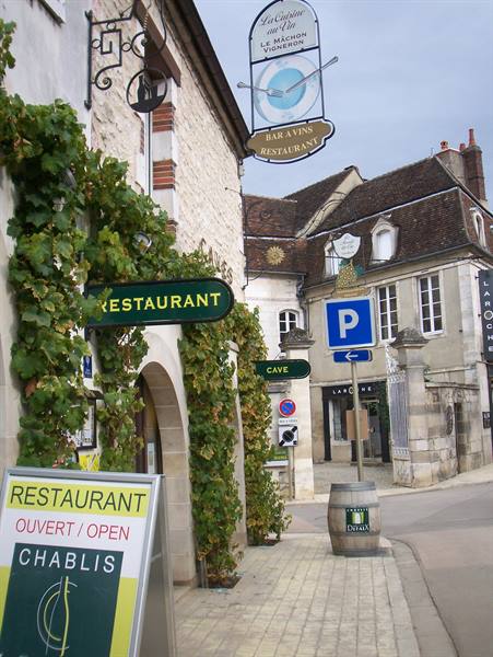 Restaurant sign La Cuisine au Vin and parking signs on paved street in Chablis