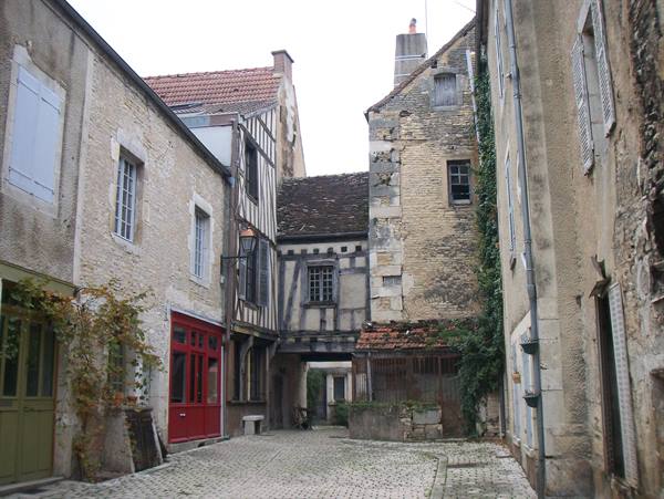 Half-timbered houses and stone facades on cobblestones, daylight