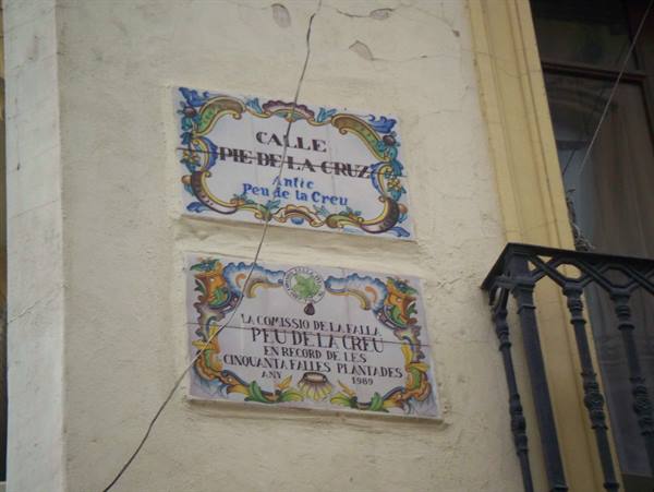 Ceramic street signs of Calle Peu de la Creu on plastered wall