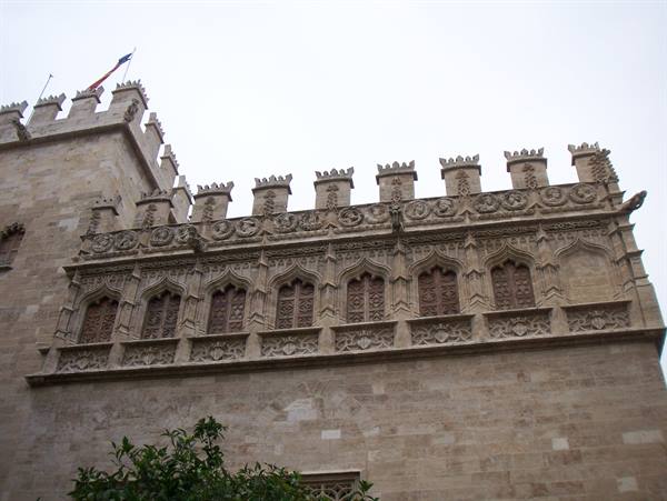 Gothic stone facade with battlements and arched windows, Lonja de Valencia