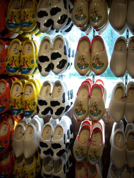 Painted wooden clogs with windmills and cow patterns hanging in a shop
