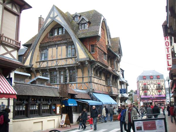 Half-timbered buildings in Deauville, people walking along the street