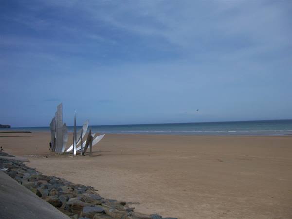 The steel Les Braves monument standing on Omaha Beach sand